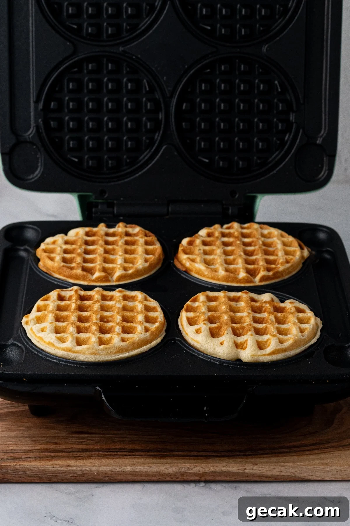 Cooking batter in waffle iron until waffles are golden brown with crispy edges.