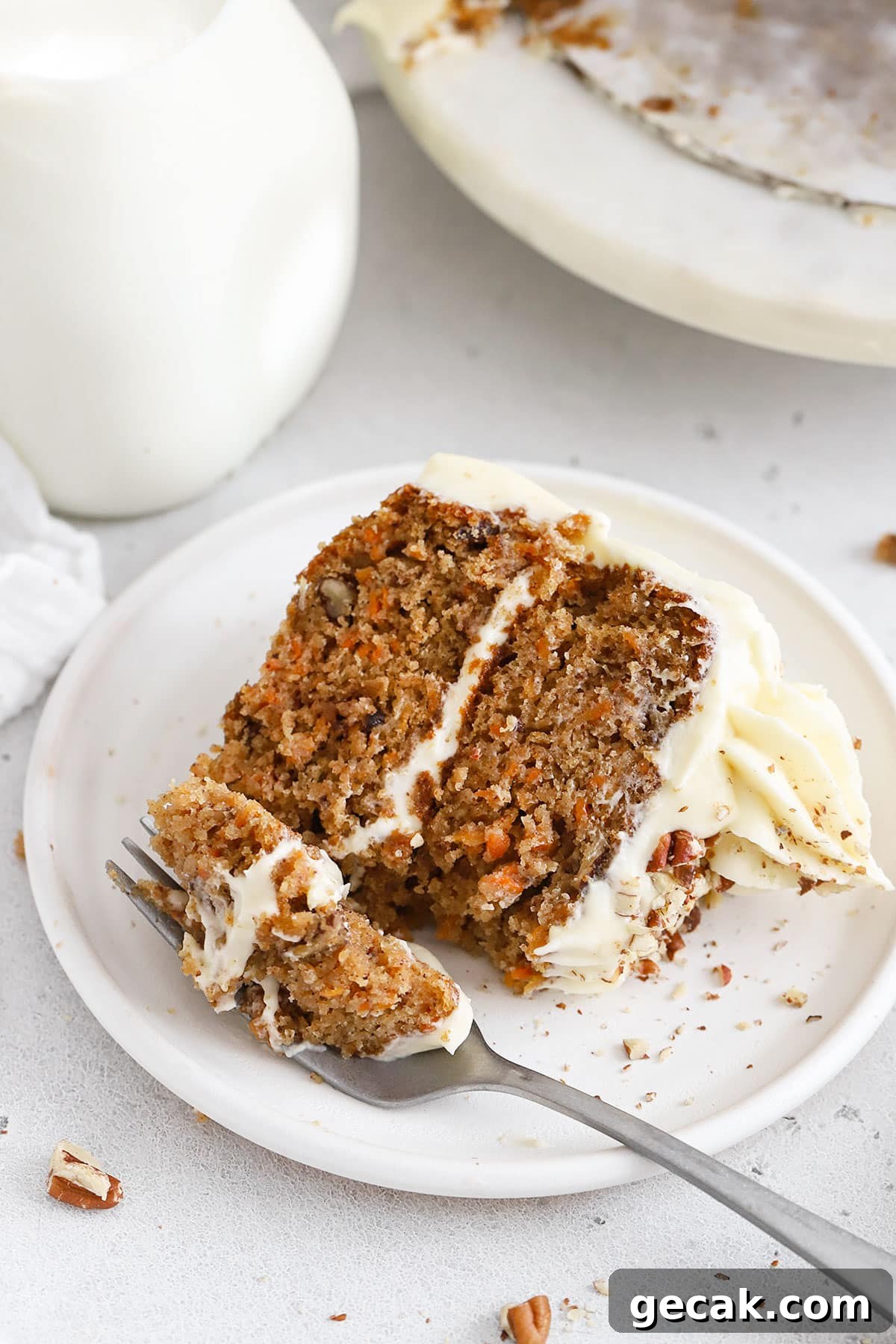 a fork cutting into a slice of two-layer gluten-free carrot cake