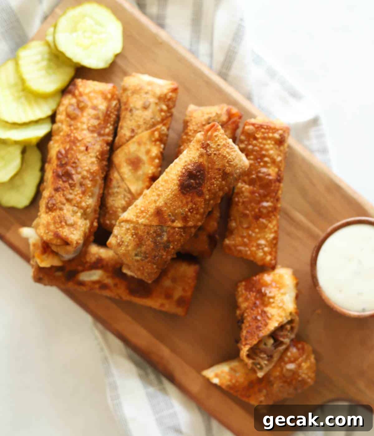 BBQ Pulled Pork Egg Rolls (Southern-Style Redneck Egg Rolls) 11 Egg rolls on wooden platter with ranch and pickles.