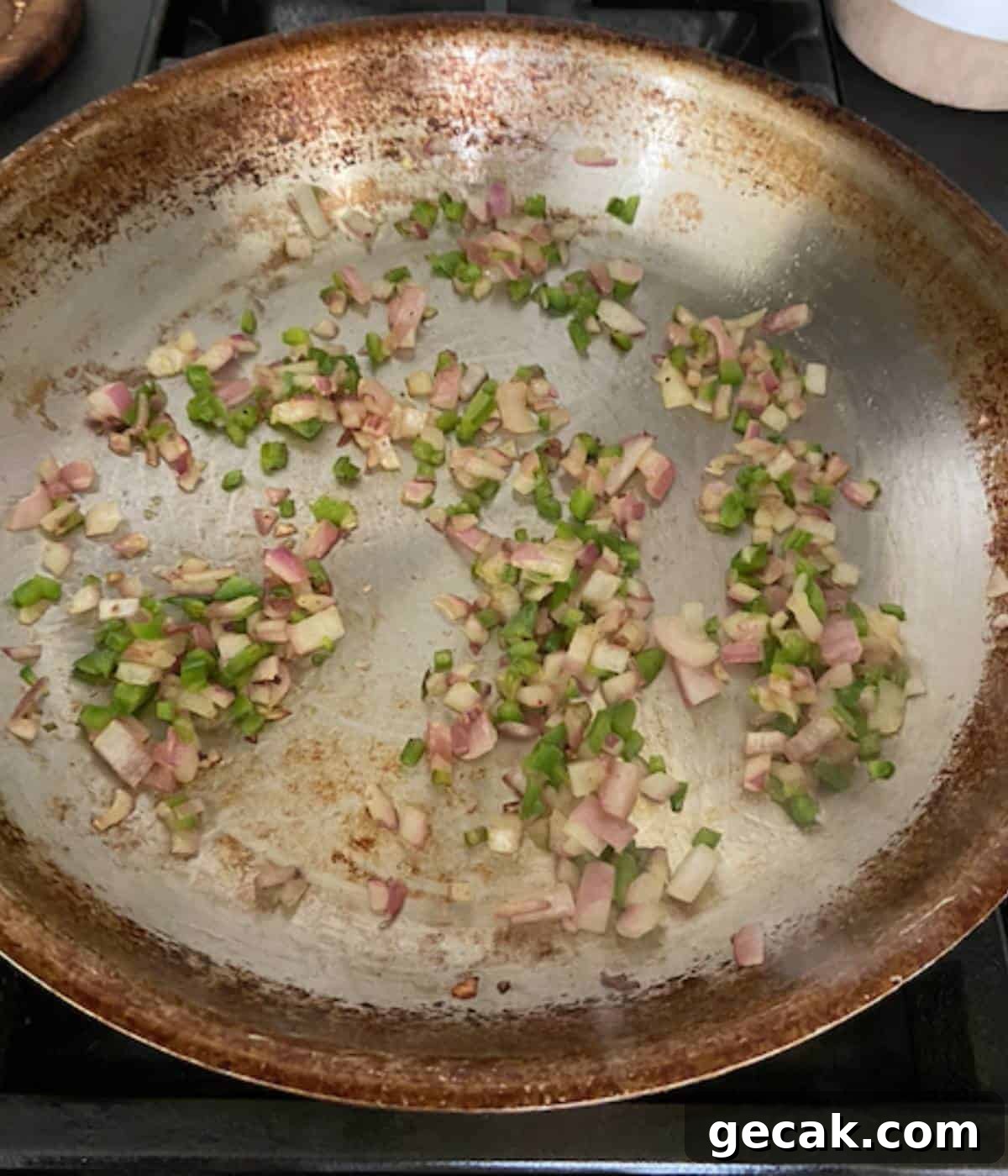 BBQ Pulled Pork Egg Rolls (Southern-Style Redneck Egg Rolls) 4 Red onion and jalapeño cooking in oil in pan.