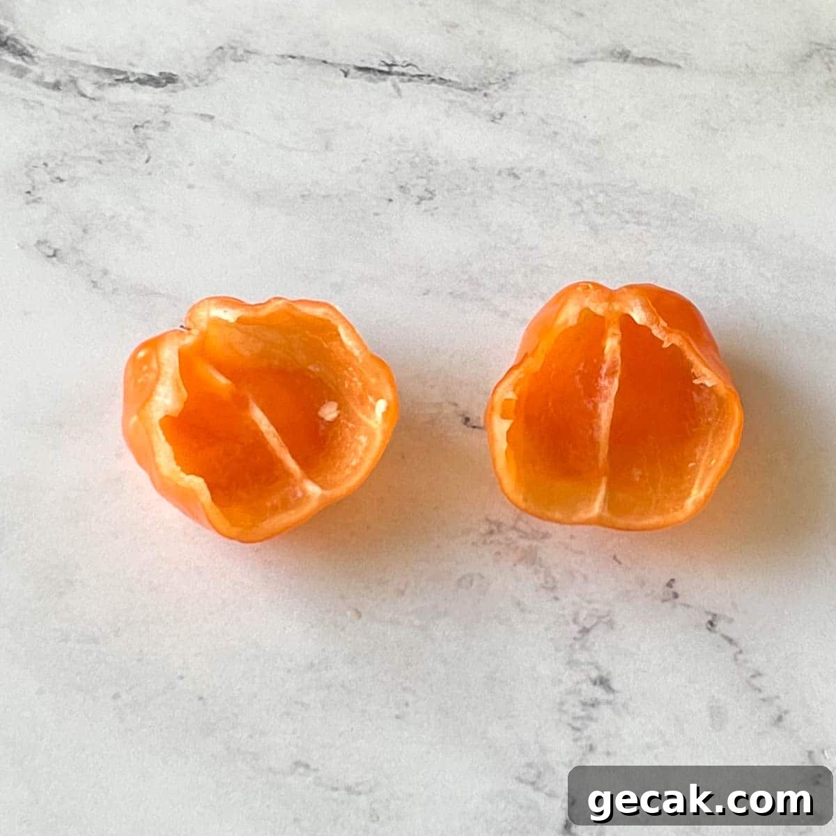 A deseeded and deveined habanero pepper sits on a white marble counter.