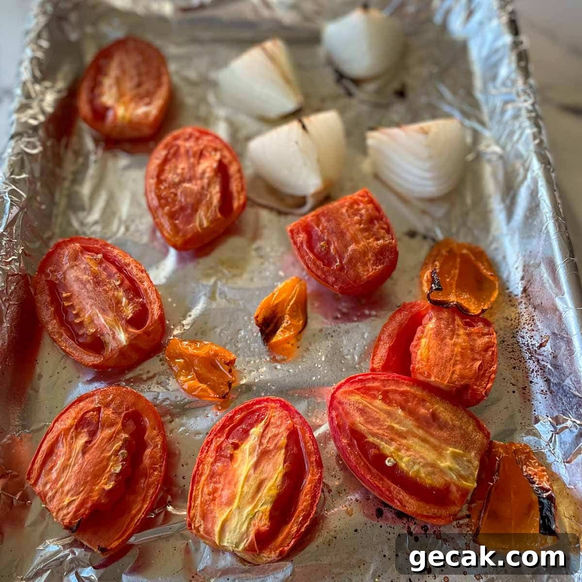 Roasted tomato, habanero, and onion are shown on a sheet tray.