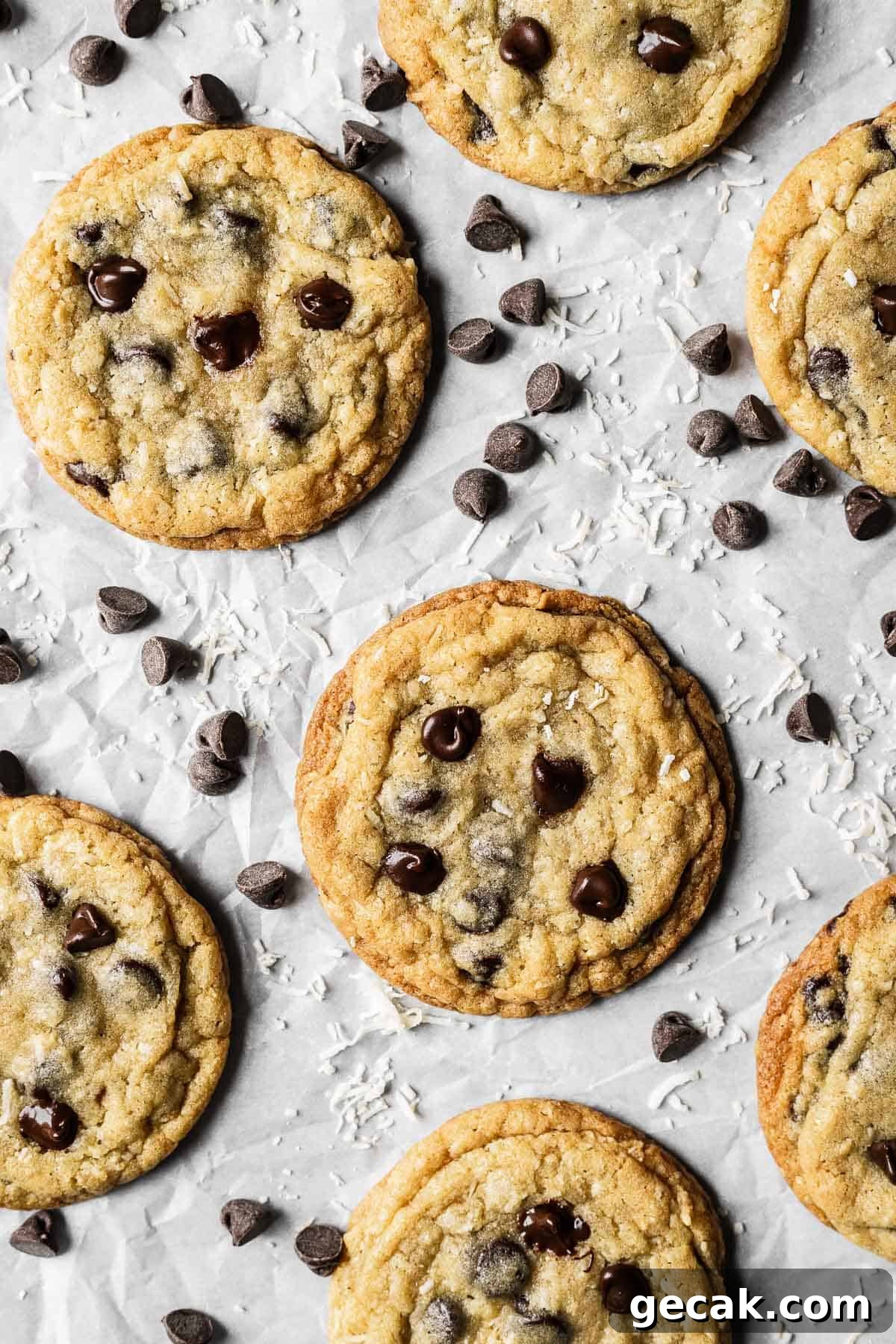 Coconut chocolate chip cookies on white parchment paper. 