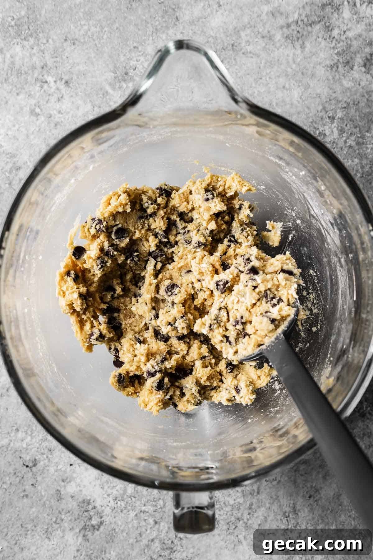 A mixing bowl with fully combined coconut chocolate chip cookie dough.
