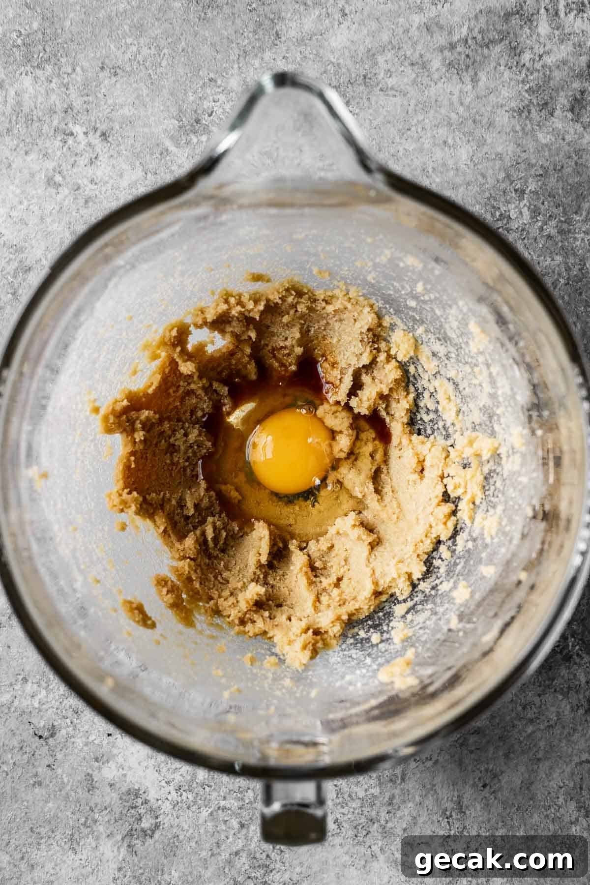 Eggs and vanilla added to creamed butter and sugar in a mixing bowl.