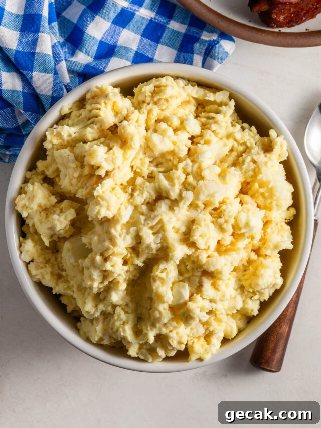 Bowl of Potato Salad with a blue and white plaid napkin in the background.