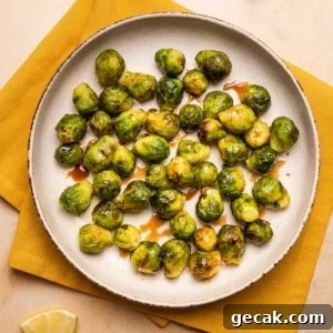 Crispy Air Fryer Frozen Brussels Sprouts Recipe 6 a plate of air fryer brussels sprouts with balsamic glaze drizzled over