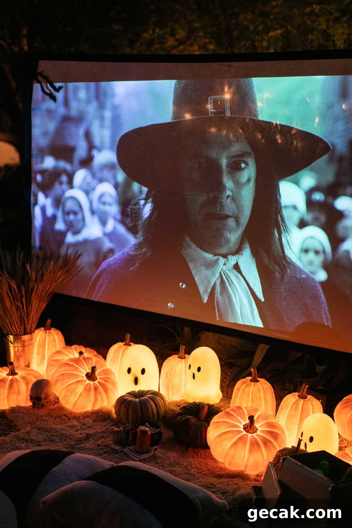 Outdoor movie with glowing pumpkins and a giant movie screen.