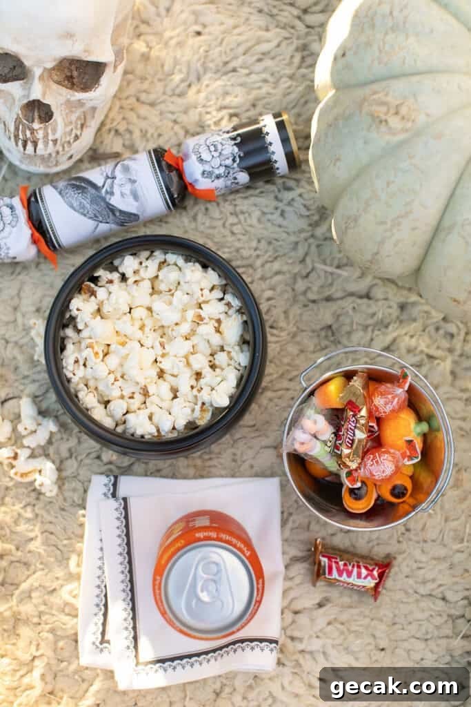 Outdoor Halloween movie snacks with candy and popcorn.